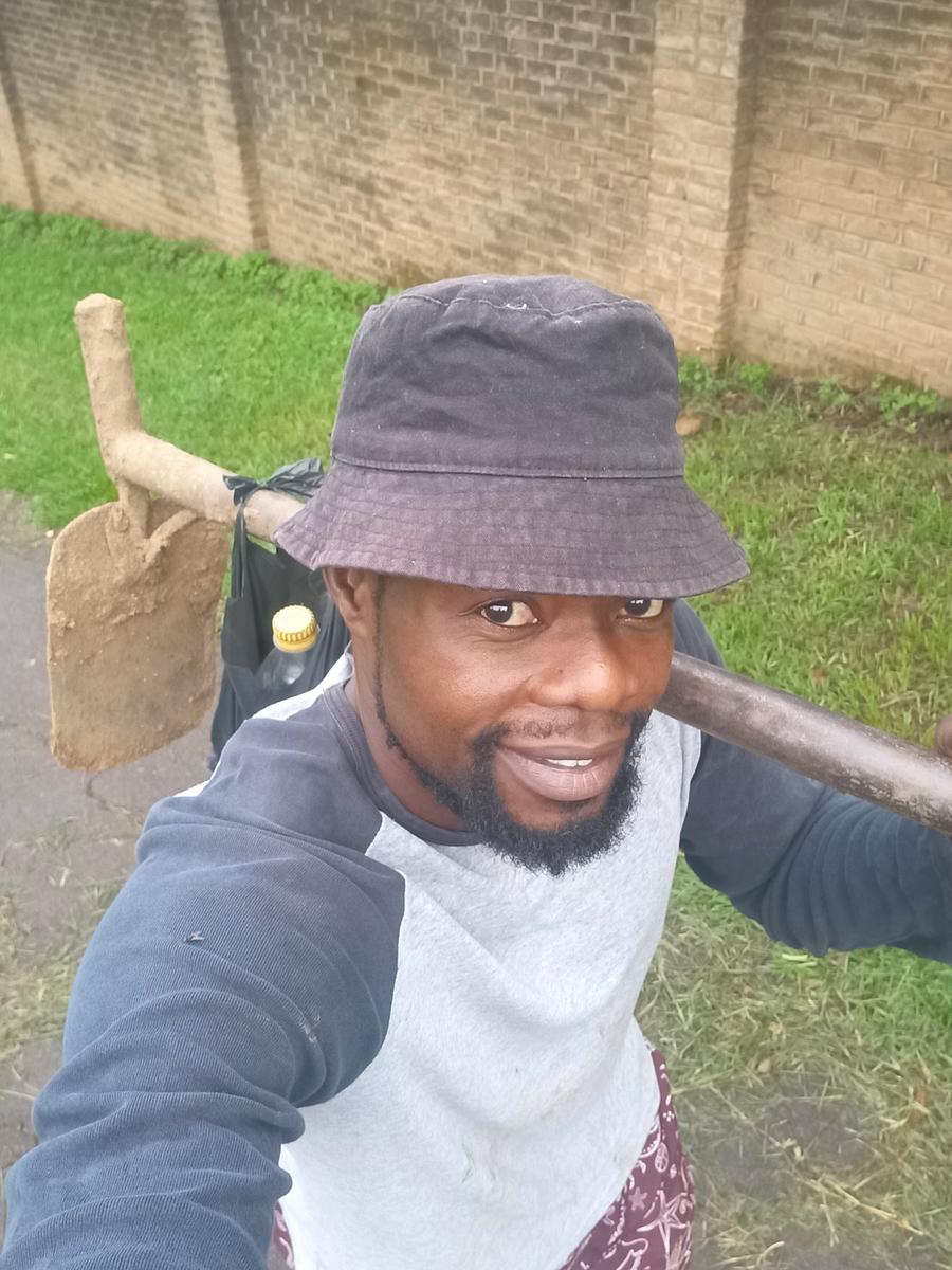 Ben with a hoe on the farm